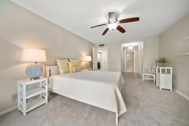 a spacious bedroom with a bed and a ceiling fan