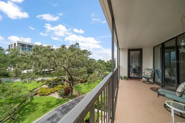 a view of a balcony with chairs and floor to ceiling window