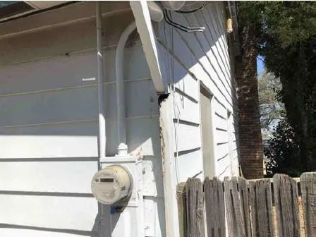 an empty room with wooden floor fireplace and windows