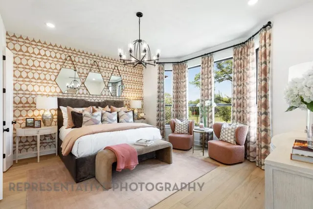 a spacious bedroom with a bed and a chandelier