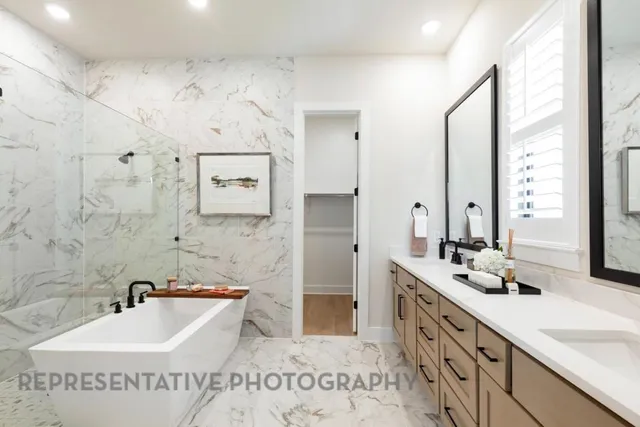 a spacious bathroom with a tub sink and mirror