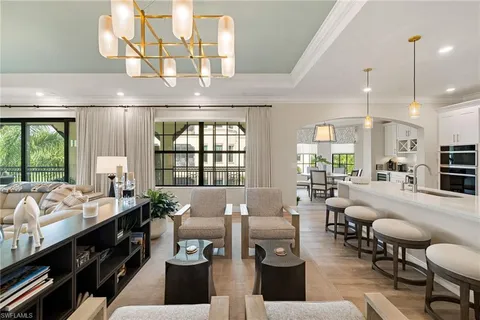 a living room with furniture fireplace and large windows