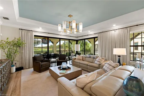 a living room with furniture and a chandelier