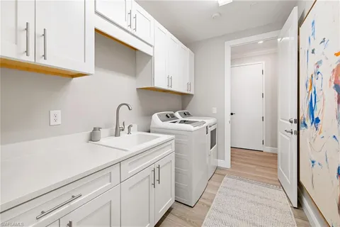 a utility room with cabinets washer and dryer