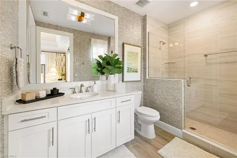 a bathroom with a double vanity sink toilet and shower