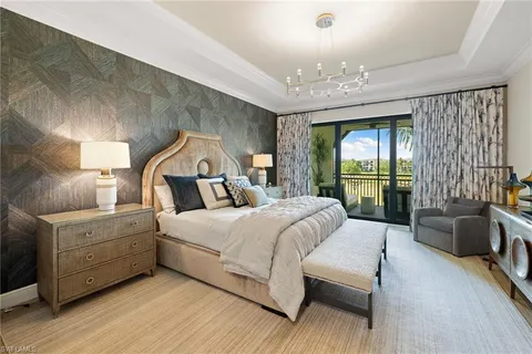 a bedroom with a large bed and a chandelier