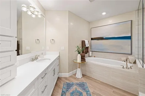 a bathroom with a tub sink and mirror