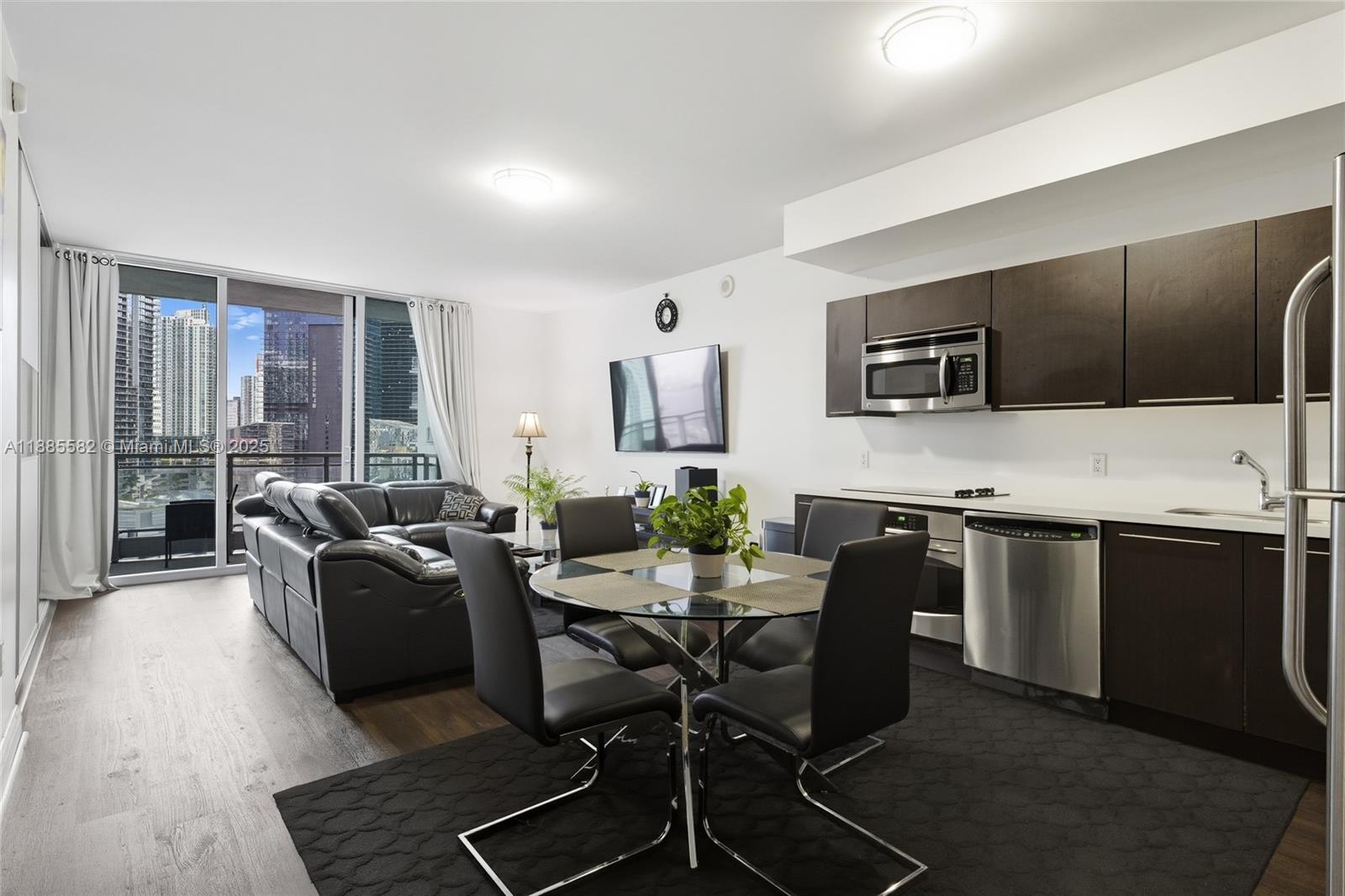 a living room with furniture a flat screen tv and kitchen view