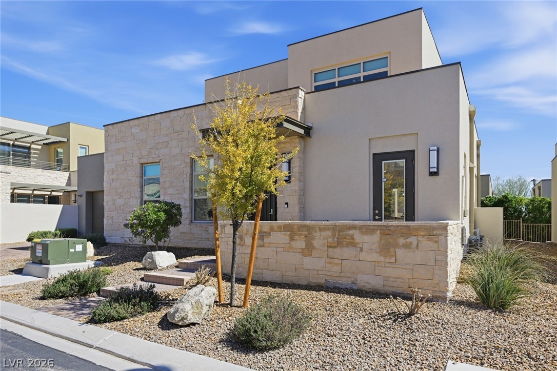 4246 Swift Street Las Vegas, NV 89135 - Photo 4 of 71 Contemporary house featuring stone siding, stucco siding, and a patio area