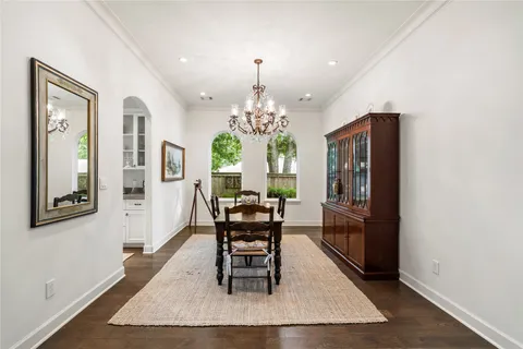a dining room with chandelier and wooden floor