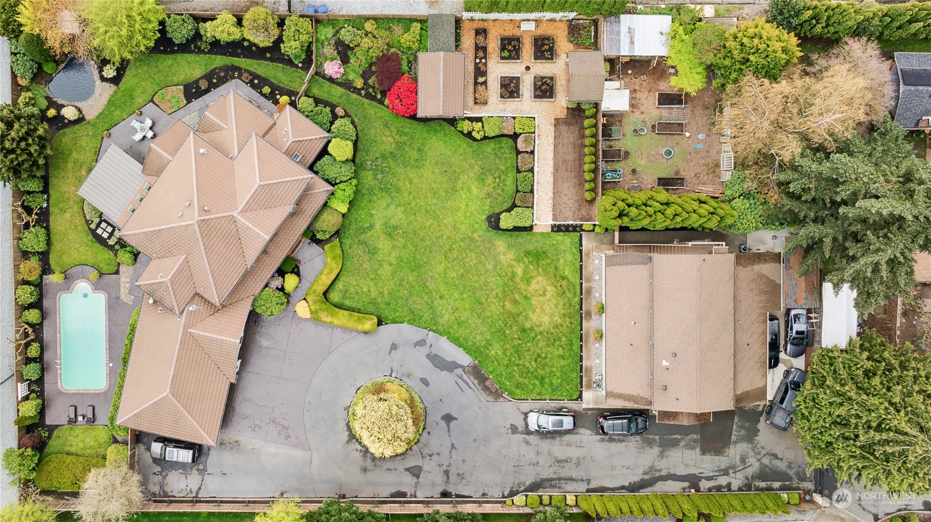 an aerial view of a house with a yard and a large tree