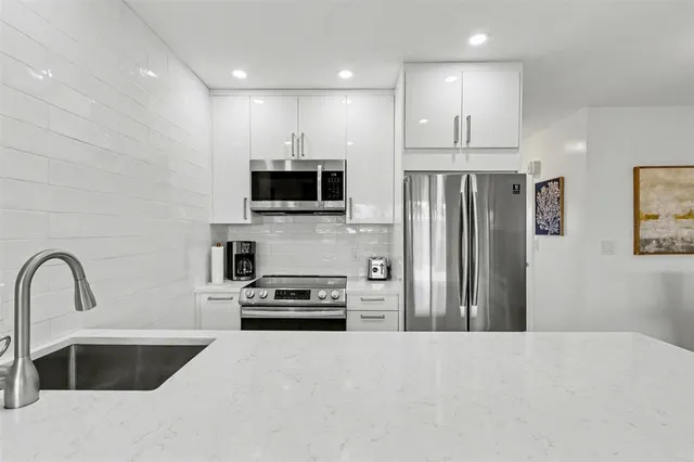 a kitchen with kitchen island a refrigerator sink and stove