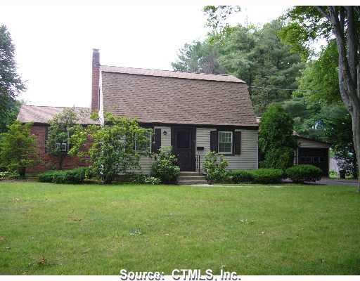 a front view of a house with a garden and yard