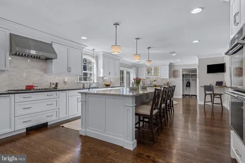 a living room with furniture a wooden floor and kitchen view