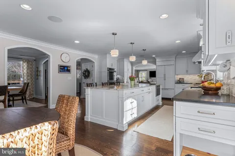 a kitchen with kitchen island granite countertop a sink a counter space and stainless steel appliances