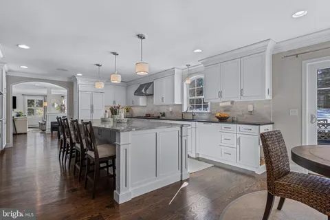 a view of kitchen with dining table chairs and wooden floor