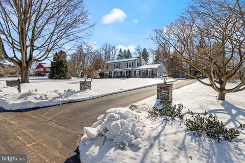 a front view of a house with a yard covered in snow