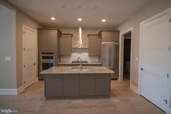 a kitchen with kitchen island stainless steel appliances a sink and refrigerator