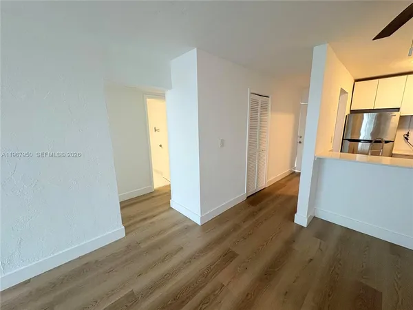a view of a kitchen with wooden floor and electronic appliances