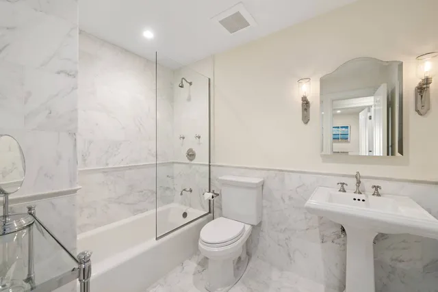 a bathroom with a sink a toilet and shower