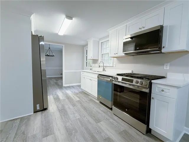 a kitchen with stainless steel appliances a stove a microwave and sink