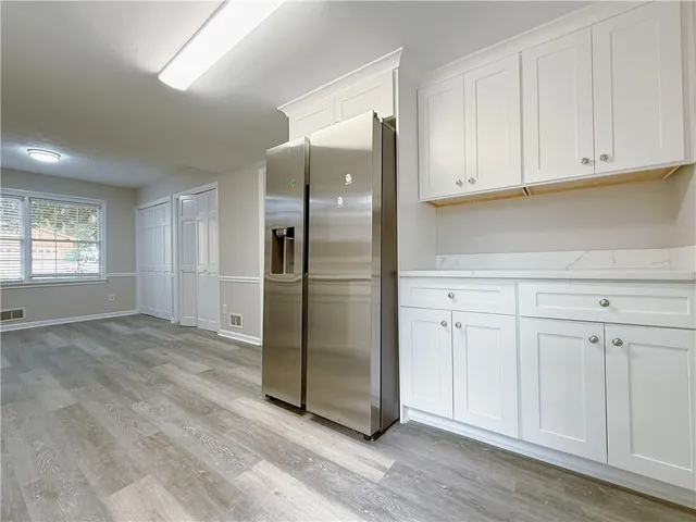a view of empty room with window and wooden floor