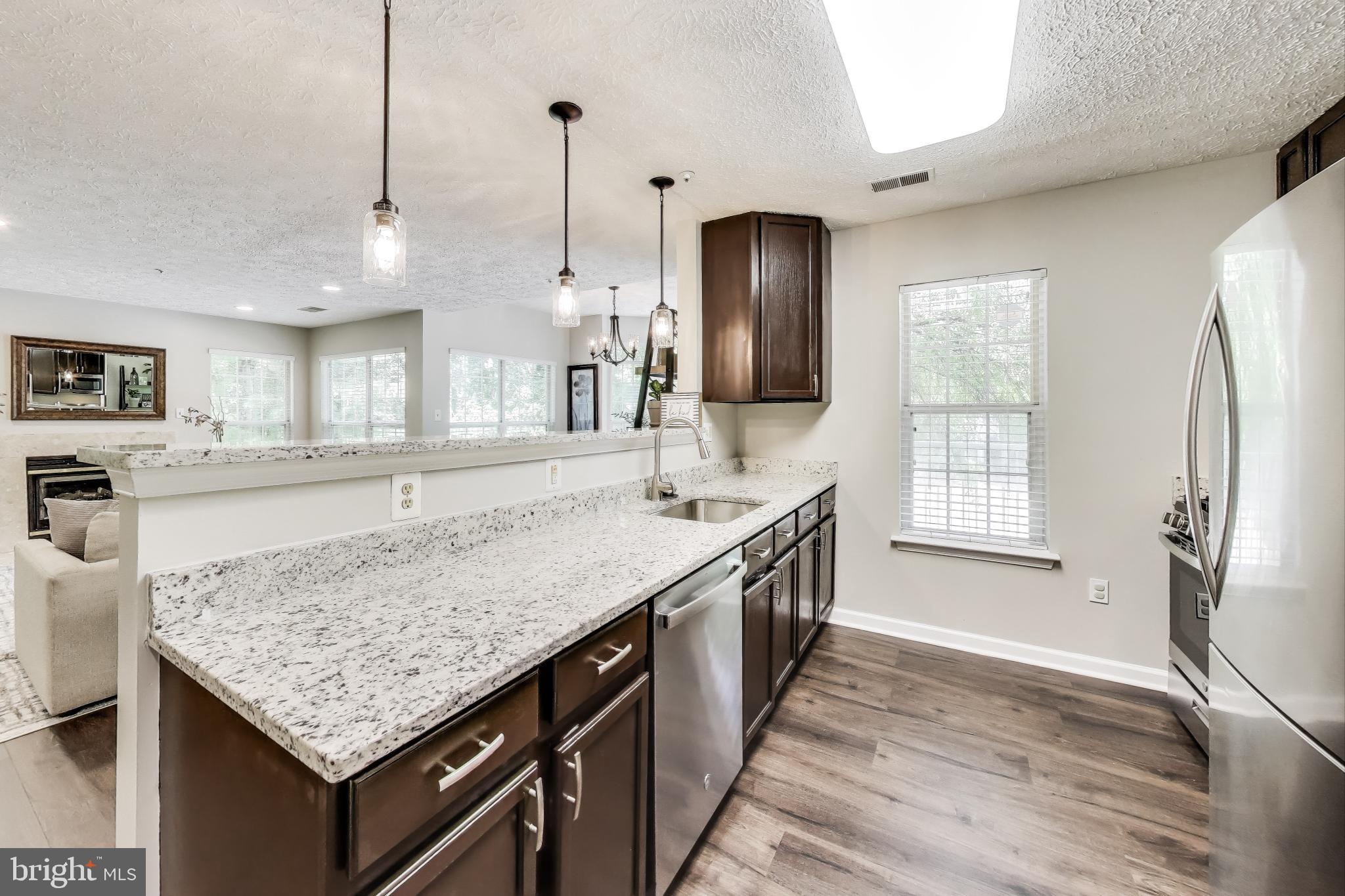 15602 Everglade Lane, Unit 2203 Bowie, MD 20716 - Photo 11 of 24 a kitchen with stainless steel appliances granite countertop a sink stove and refrigerator
