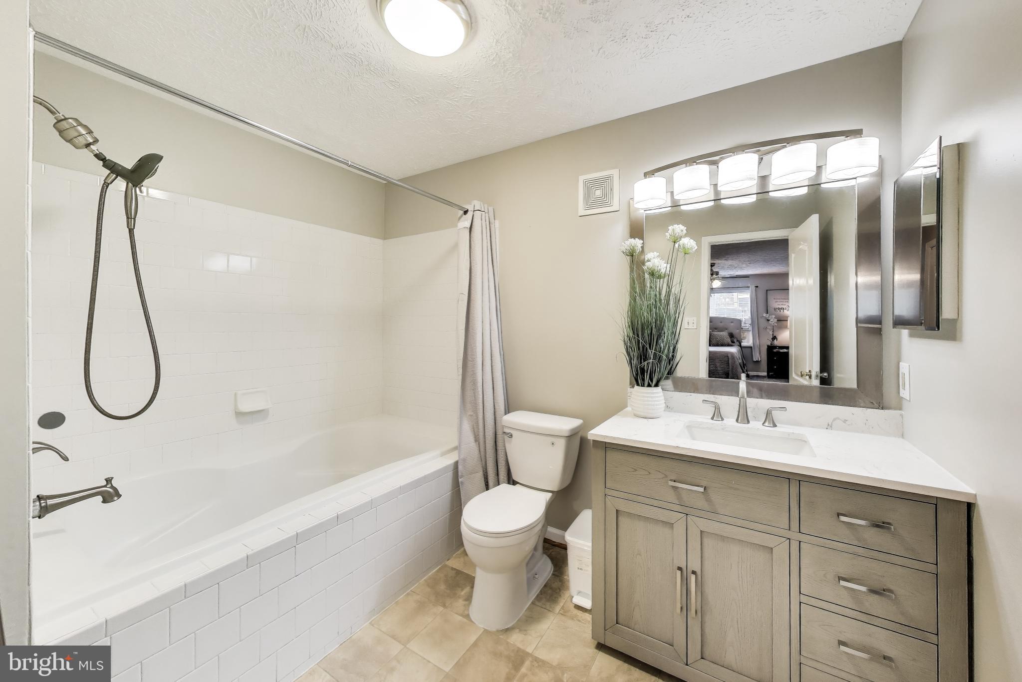 15602 Everglade Lane, Unit 2203 Bowie, MD 20716 - Photo 16 of 24 a bathroom with a double vanity sink toilet mirror and shower