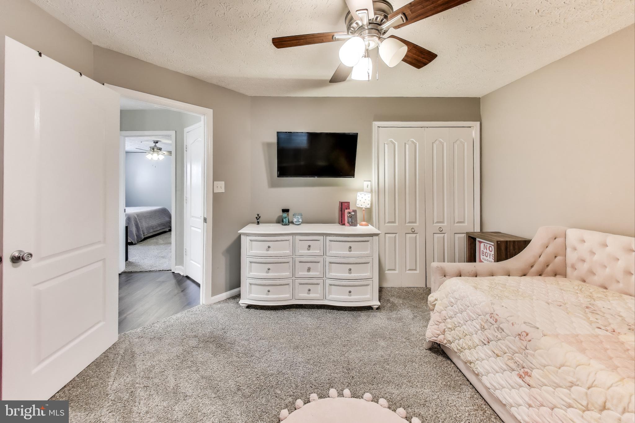 15602 Everglade Lane, Unit 2203 Bowie, MD 20716 - Photo 18 of 24 a bedroom with a bed and flat screen tv