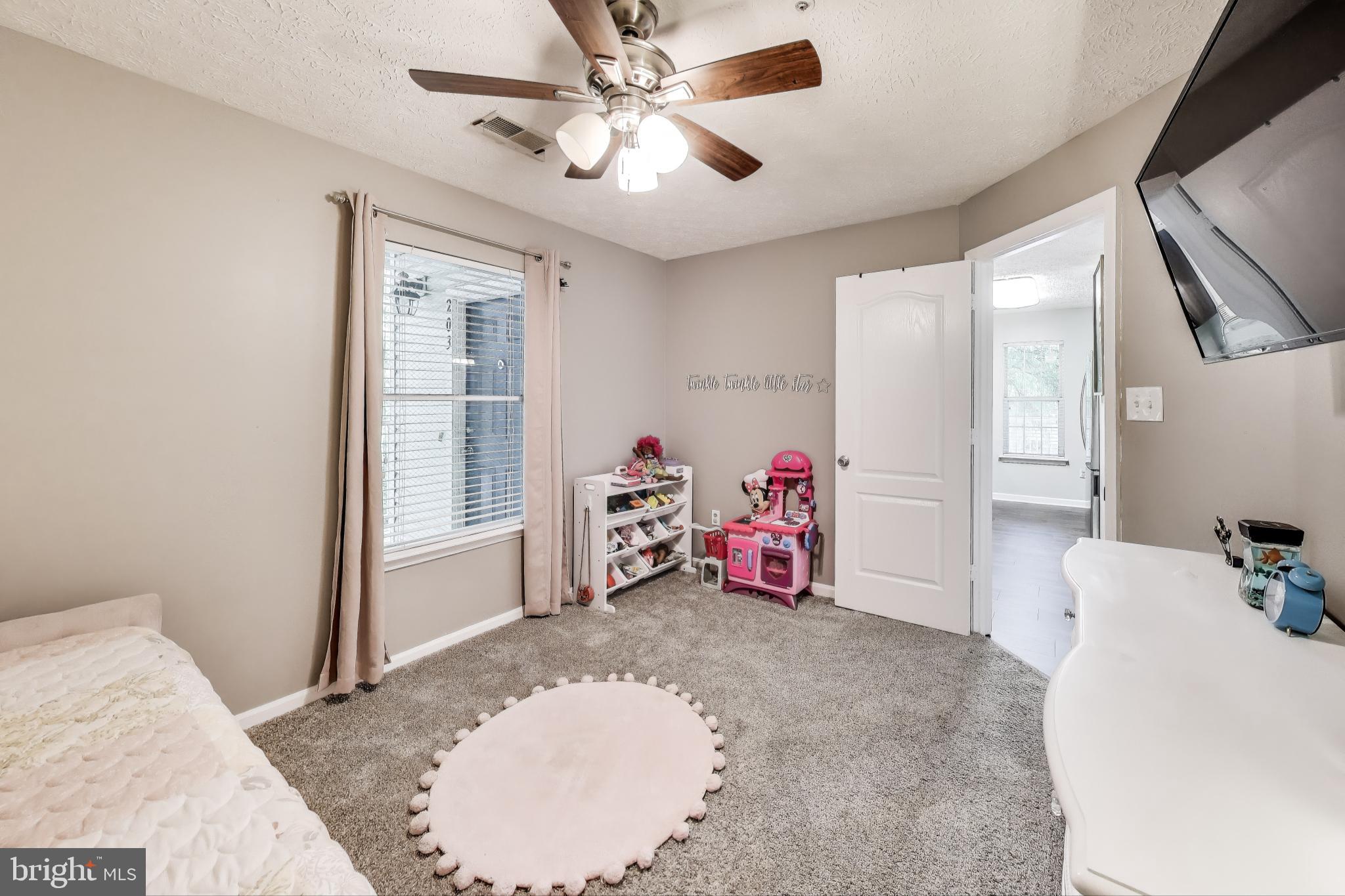 15602 Everglade Lane, Unit 2203 Bowie, MD 20716 - Photo 19 of 24 a view of a bedroom with a bed and a chandelier