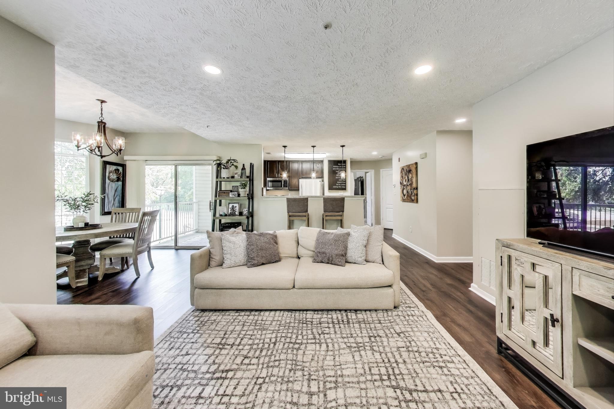 15602 Everglade Lane, Unit 2203 Bowie, MD 20716 - Photo 3 of 24 a living room with furniture and a flat screen tv