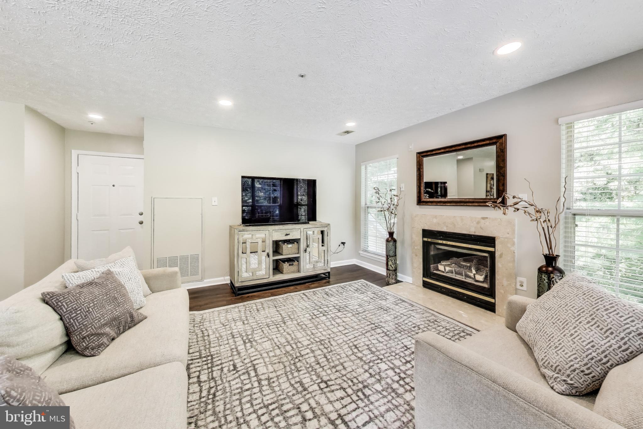 15602 Everglade Lane, Unit 2203 Bowie, MD 20716 - Photo 4 of 24 a living room with furniture a fireplace and a flat screen tv