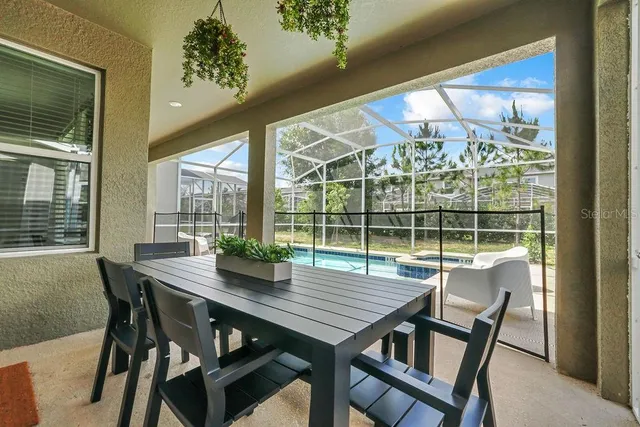 a view of a dining room with furniture large windows and wooden floor