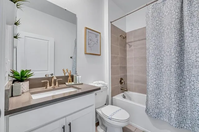 a bathroom with a sink a toilet a tub and shower