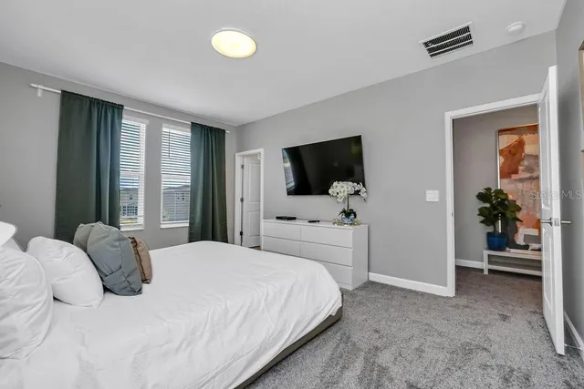 a bedroom with a bed and a flat tv screen in it