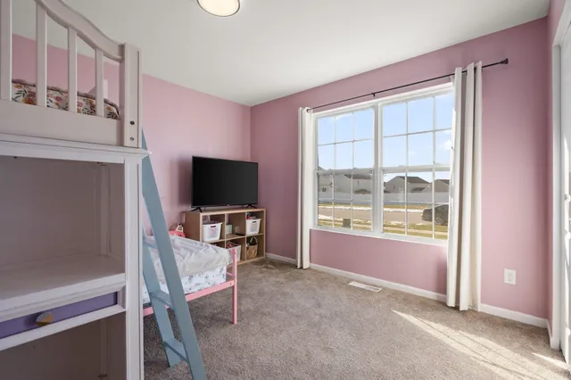 a living room with furniture a flat screen tv and a window