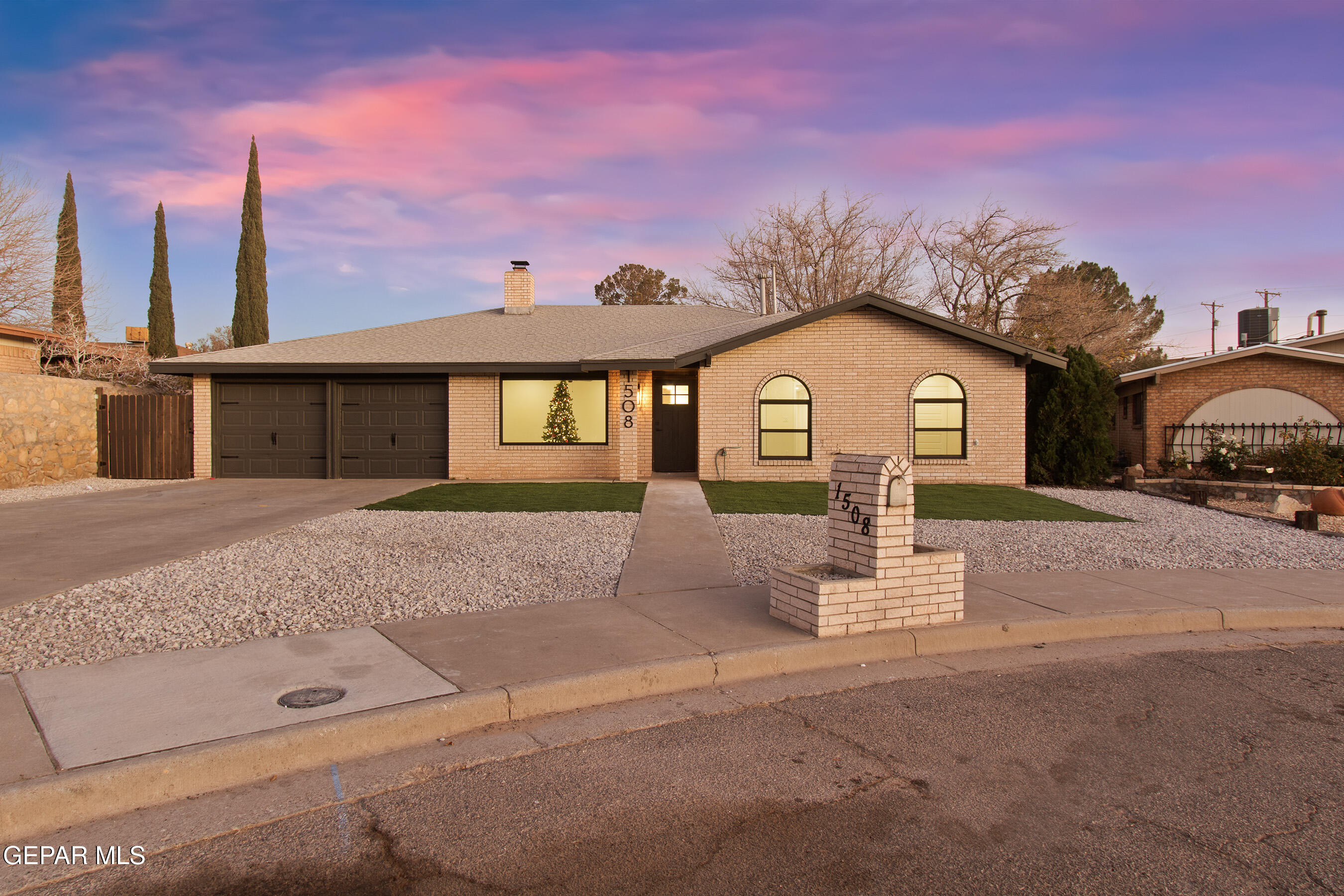 a front view of a house with a garden and garage