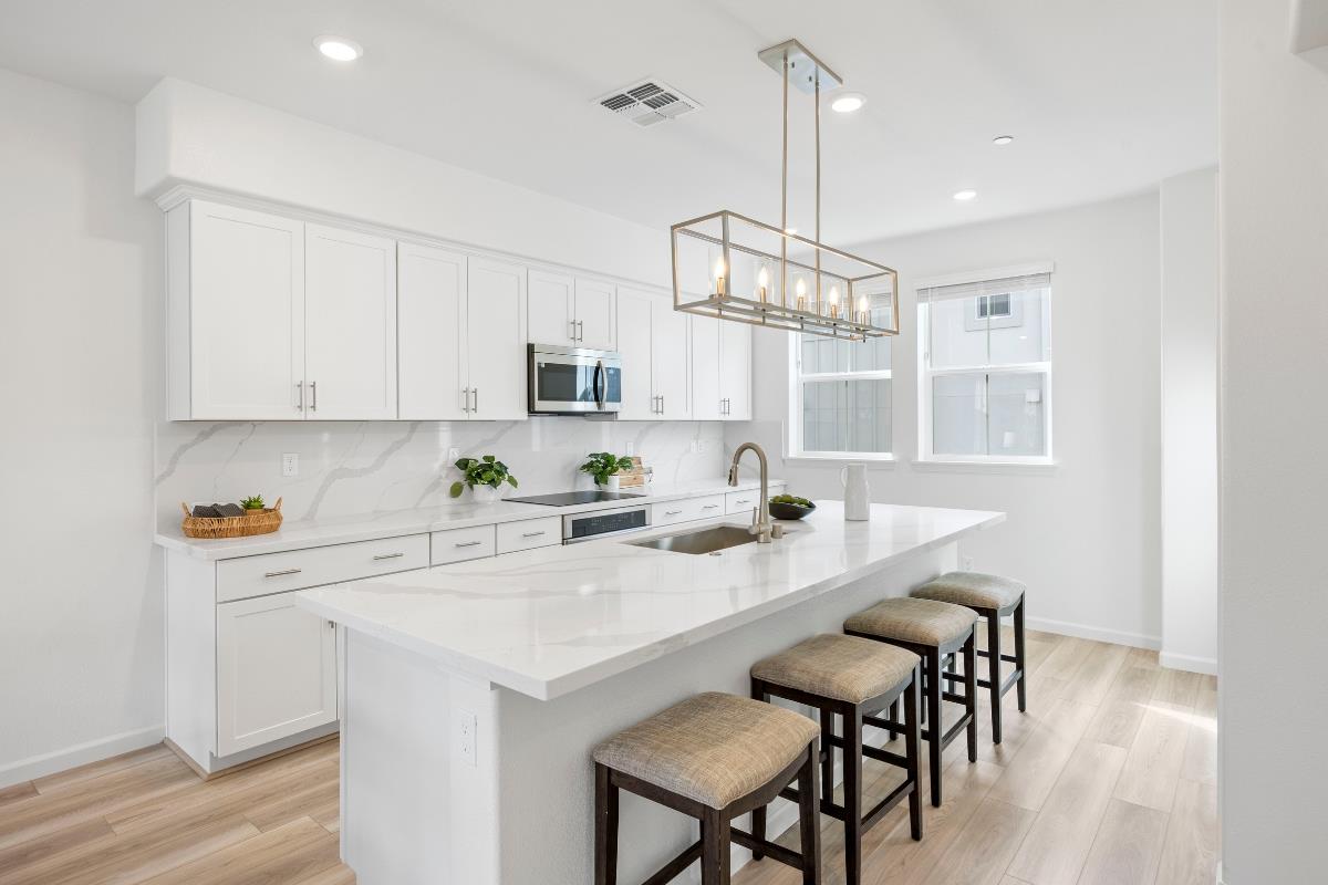 3775 Castro Valley Boulevard Castro Valley, CA 94546 - Photo 11 of 35 a kitchen with stainless steel appliances a white table chairs and a refrigerator