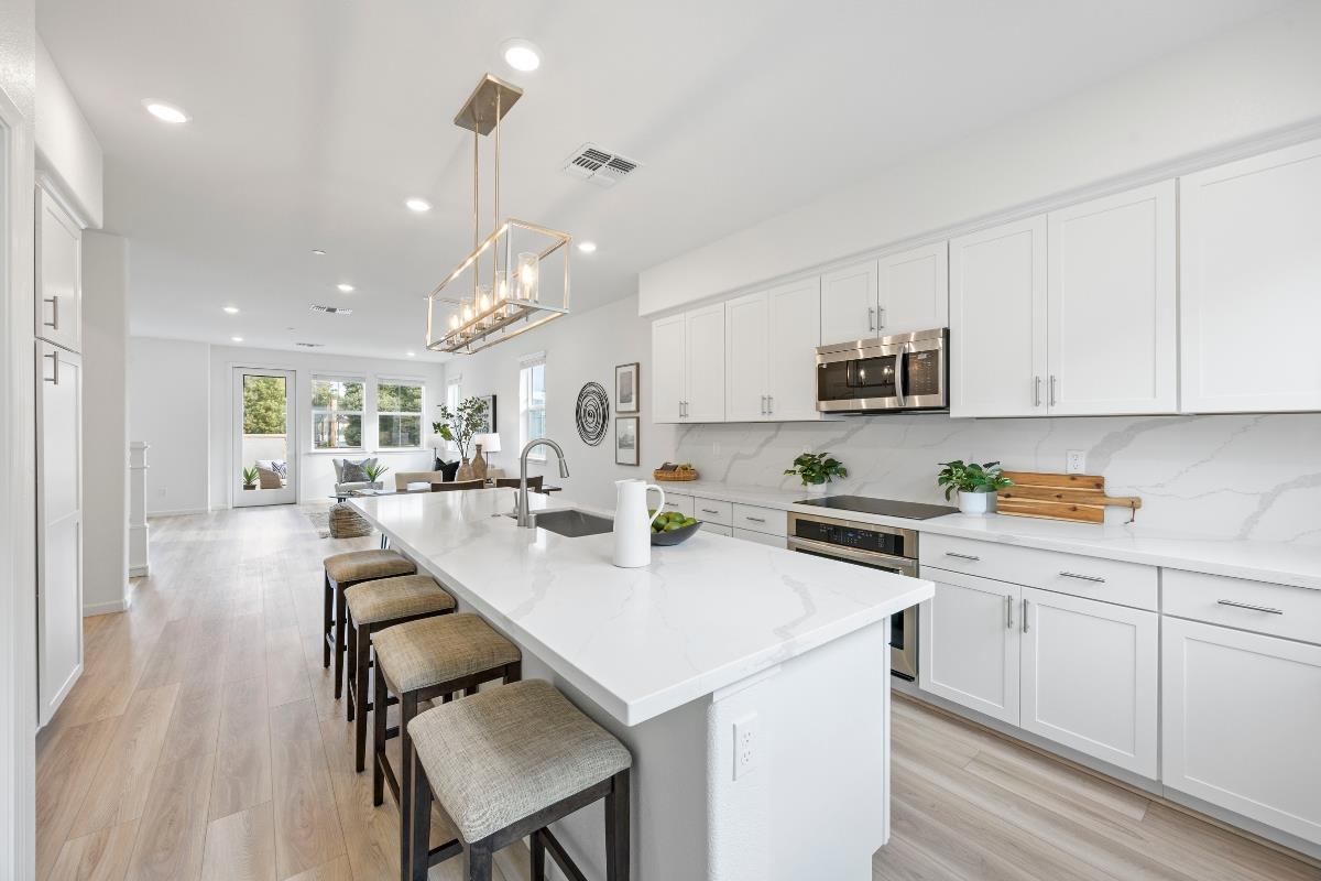 3775 Castro Valley Boulevard Castro Valley, CA 94546 - Photo 14 of 35 a kitchen with stainless steel appliances kitchen island a table chairs sink and cabinets