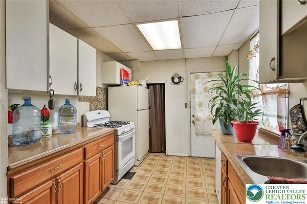 a kitchen with stainless steel appliances granite countertop a refrigerator a sink a stove and a window