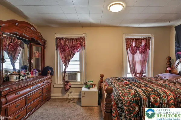 a bedroom with a bed and a painting on the wall