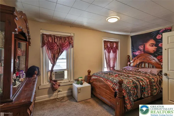 a bed sitting in a bedroom next to a window
