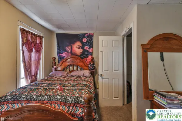 a bedroom with a bed and a painting on the wall