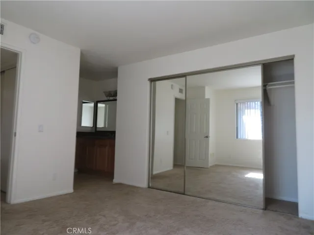 an empty room with windows and closet