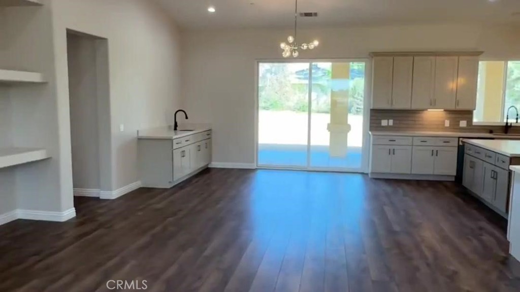14785 Tigertail Road Apple Valley, CA 92307 - Photo 2 of 20 a room with kitchen island granite countertop wooden floors and white stainless steel appliances