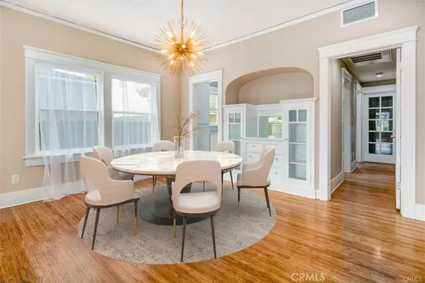a dining room with furniture a chandelier and wooden floor