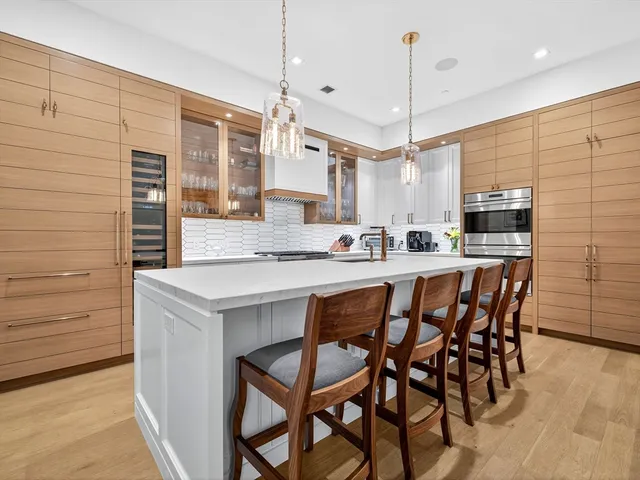 a kitchen with a dining table chairs sink and cabinets