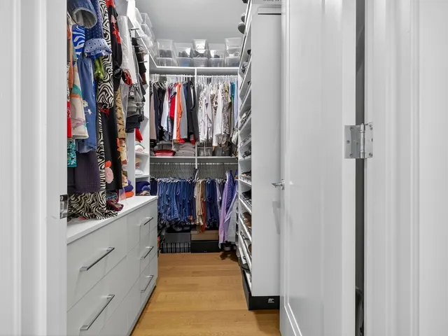a view of walk in closet with clothes and shoes