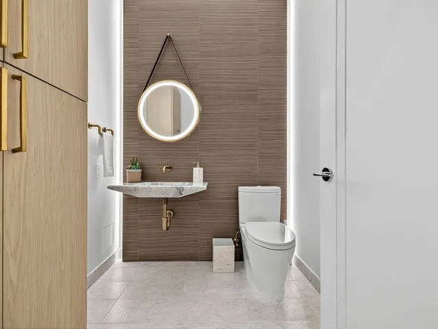 a bathroom with a toilet a sink and a mirror