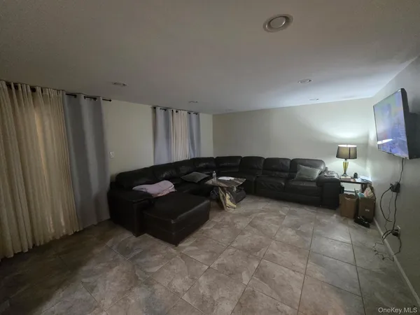 a living room with furniture and a air conditioner vent